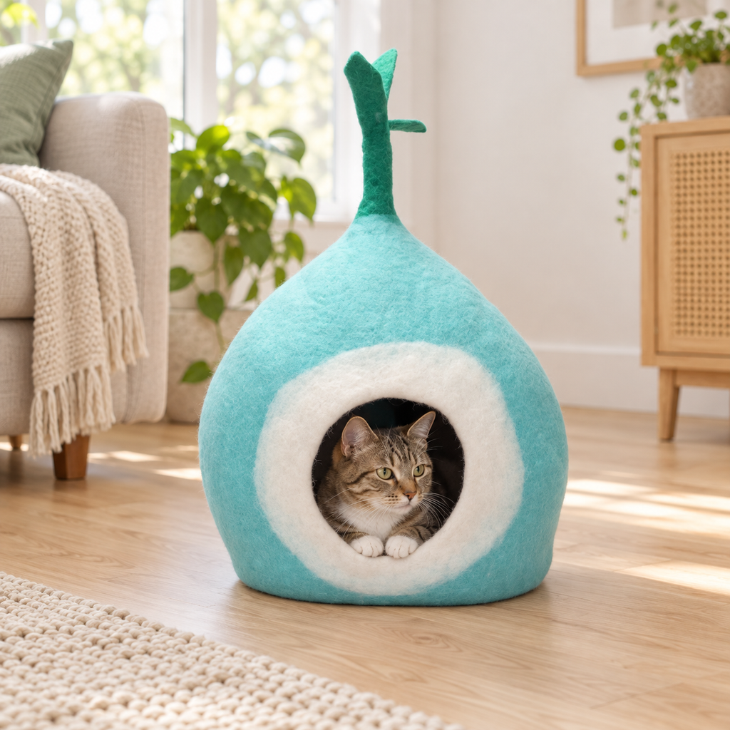Tabby cat resting inside a turquoise and white Nepal wool cat cave